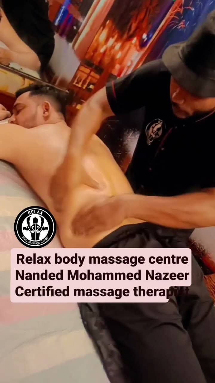 A therapist pressing along the back of a client who is lying face down on the treatment table.